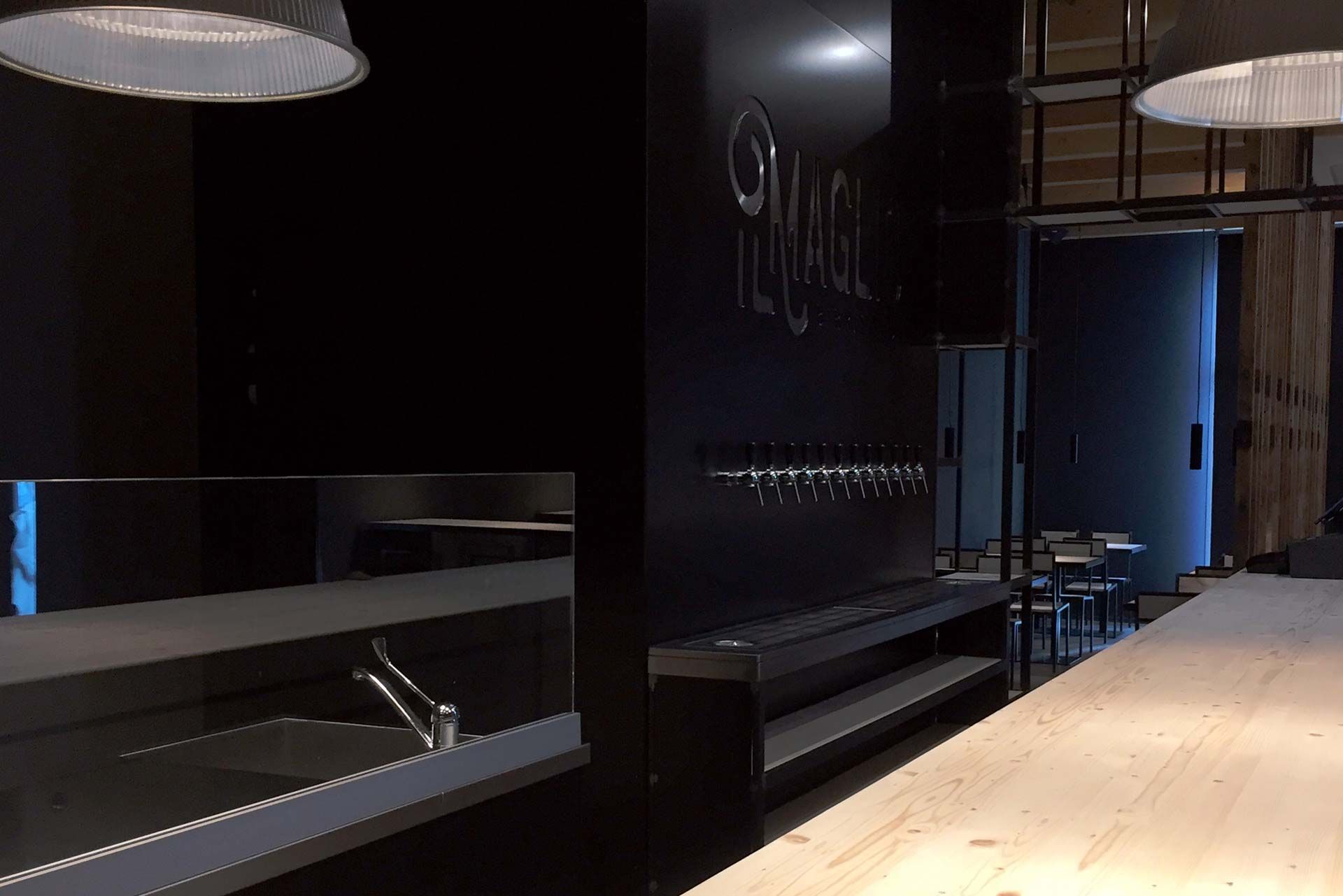 Il bancone della taproom, con il marchio il Maglio sulla parete scura