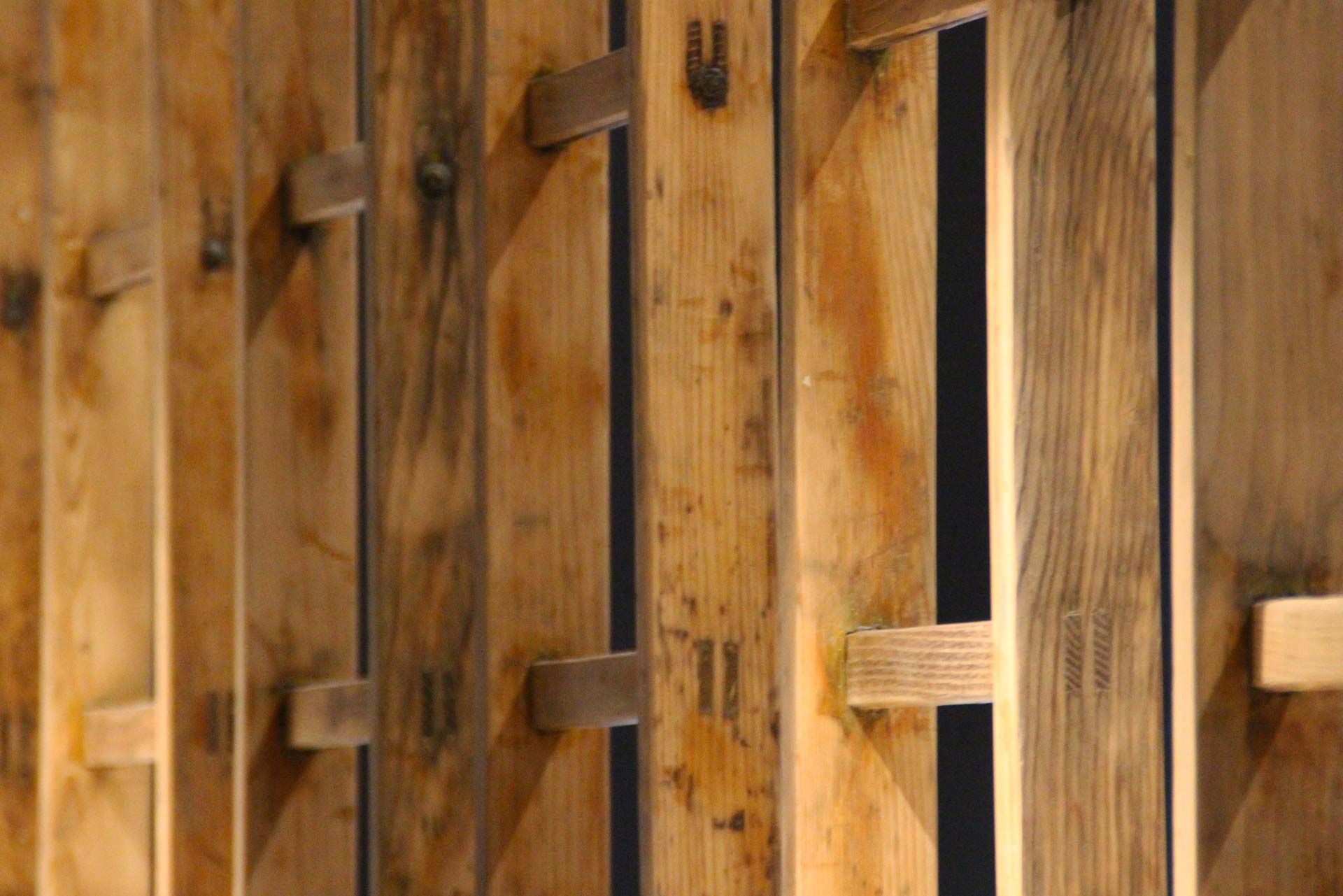 Dettaglio delle scale a pioli in legno grezzo usate come divisori
