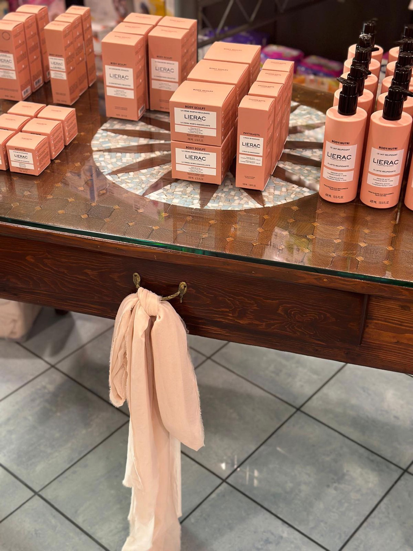 Allestimento di una farmacia con prodotti e composizioni floreali