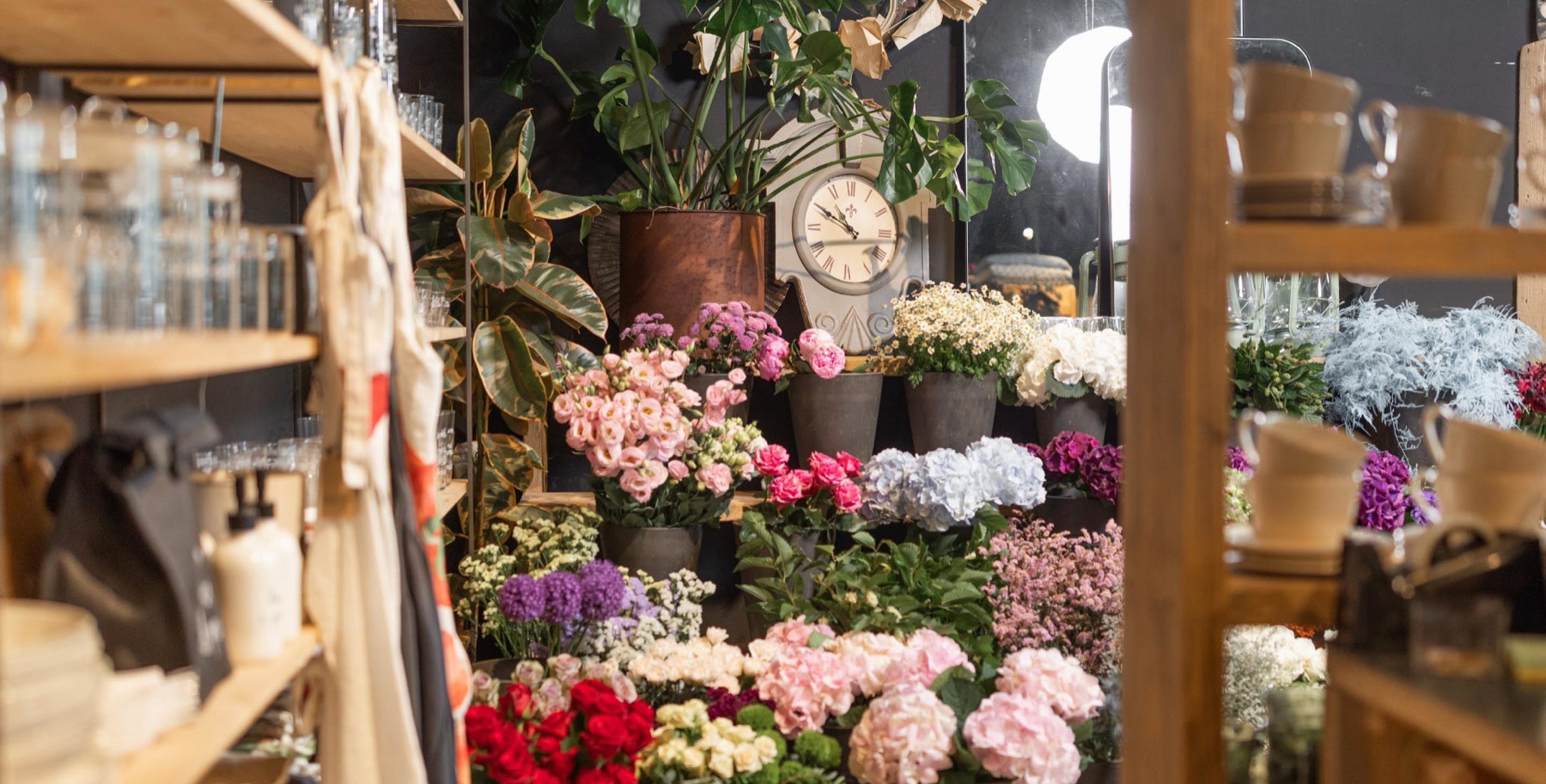 Scaffali della fioreria con fiori, vasi e oggetti per la casa