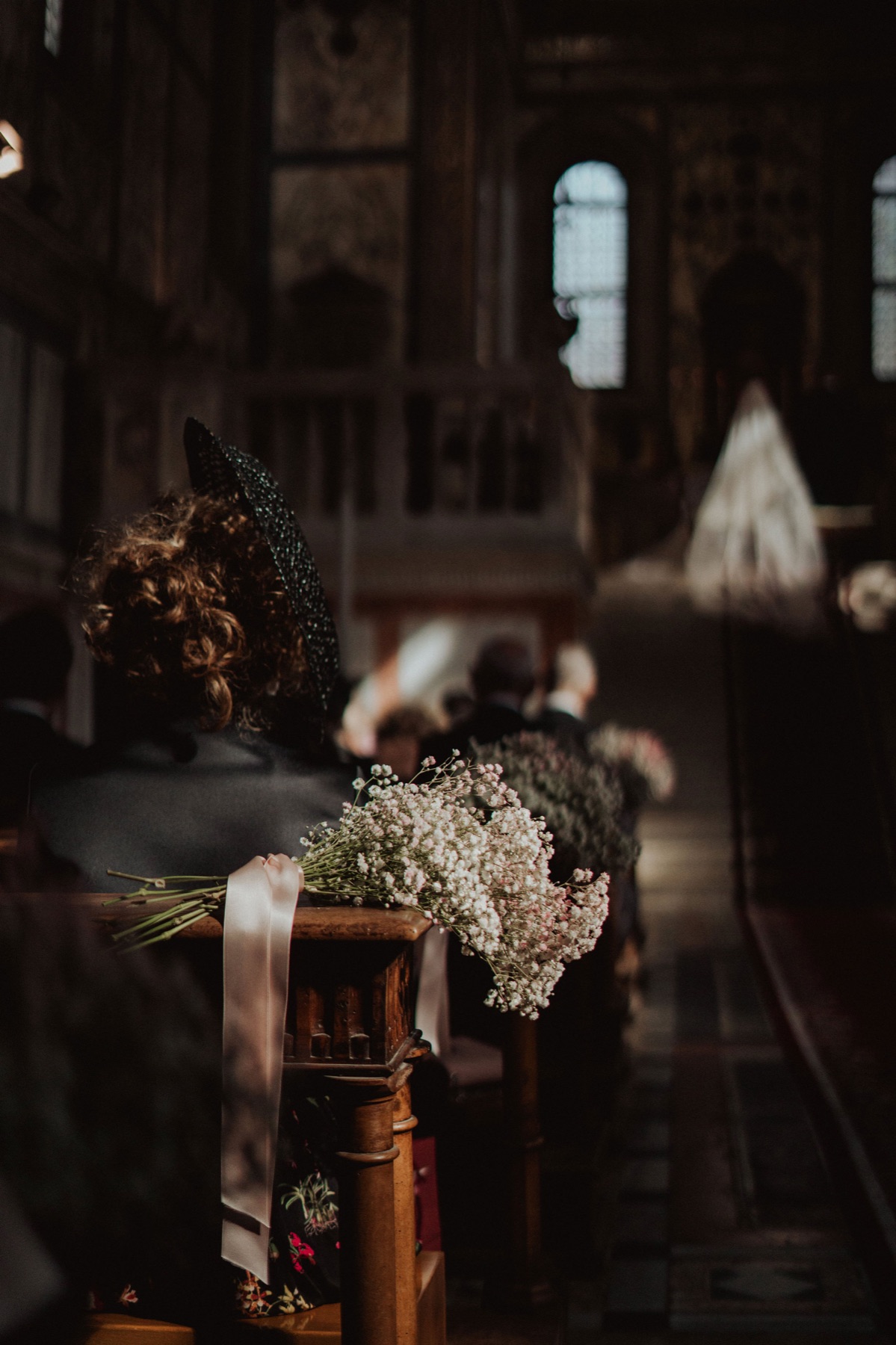 Composizione di fiori bianchi in una chiesa, fra le candele