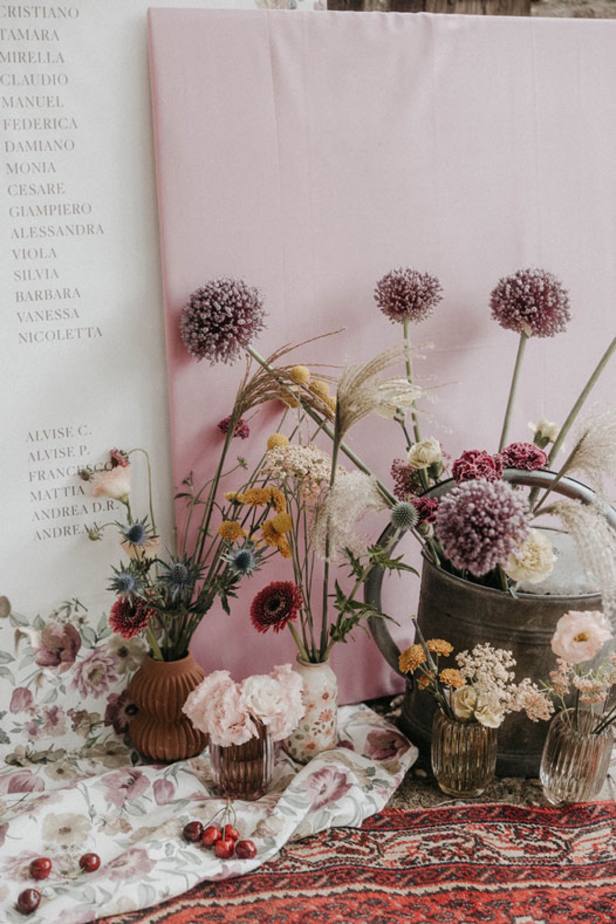 Fondale rosa con composizioni di fiori secchi e allium