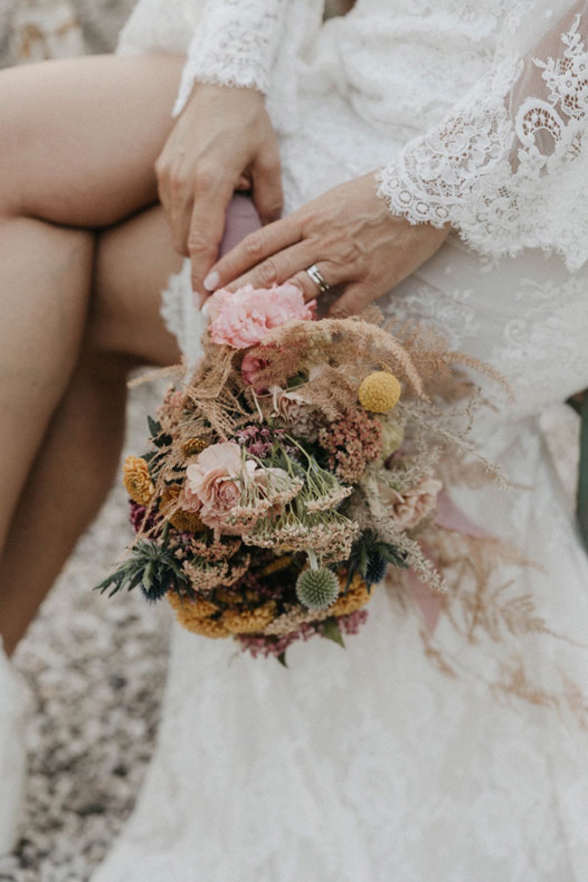 Bouquet da sposa di fiori secchi fra le mani della sposa