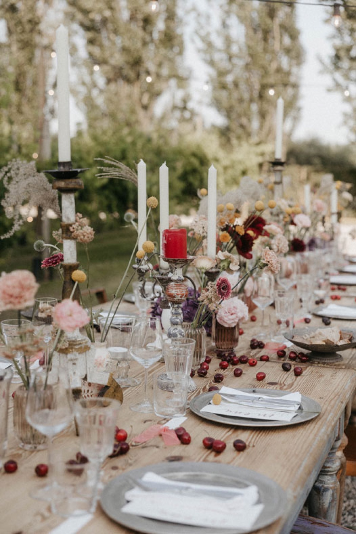 Tavolo di matrimonio allestito all’aperto con candele e fiori
