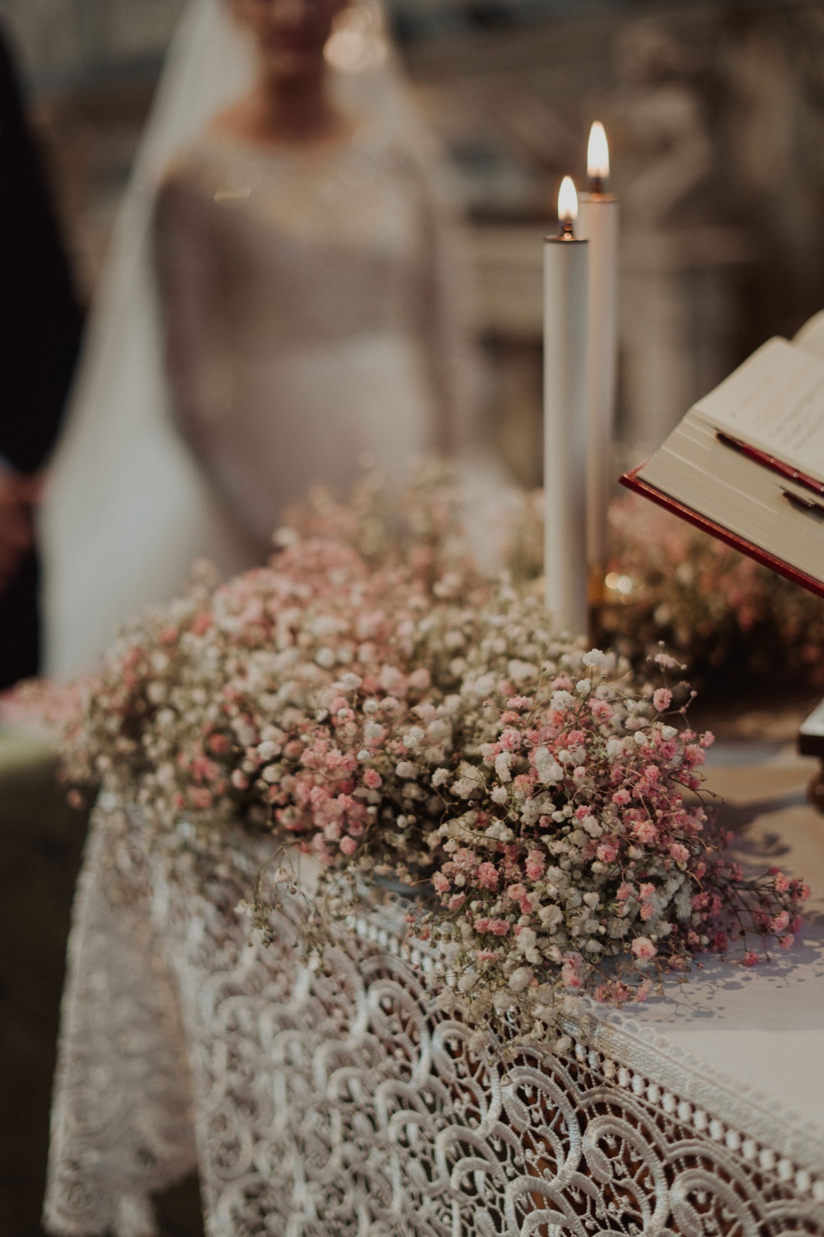 Alzate con gypsophila e segnaposto davanti a un muro di mattoni