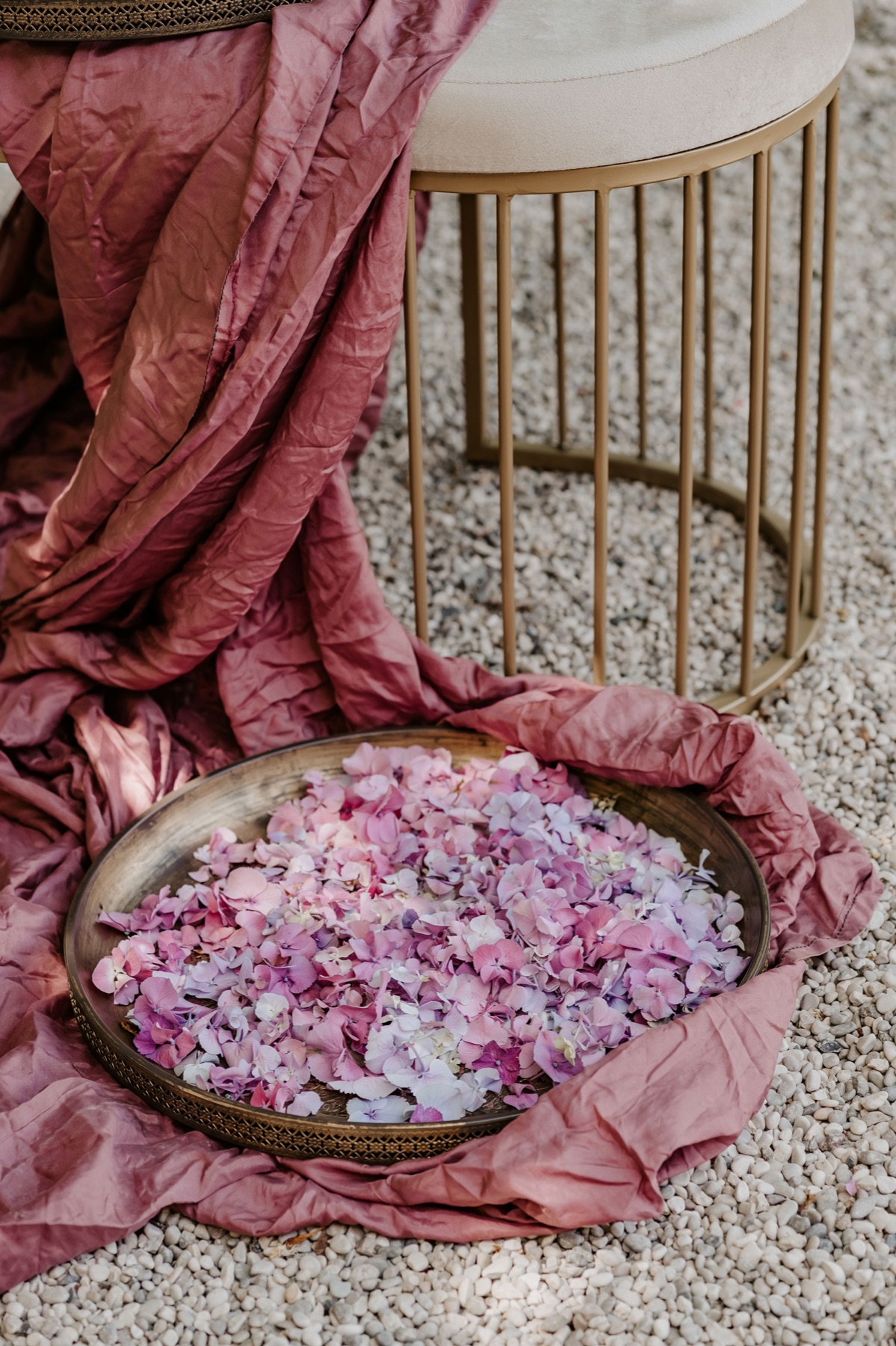 Petali di rosa in una coppa di ottone su un drappo rosa
