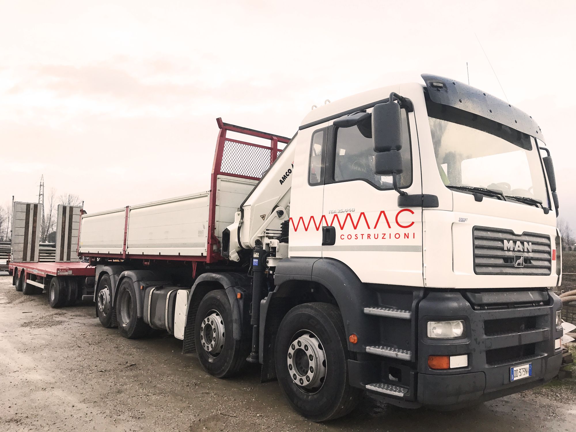 Camion con gru di MAC Costruzioni con il marchio e lo zig-zag sulla portiera