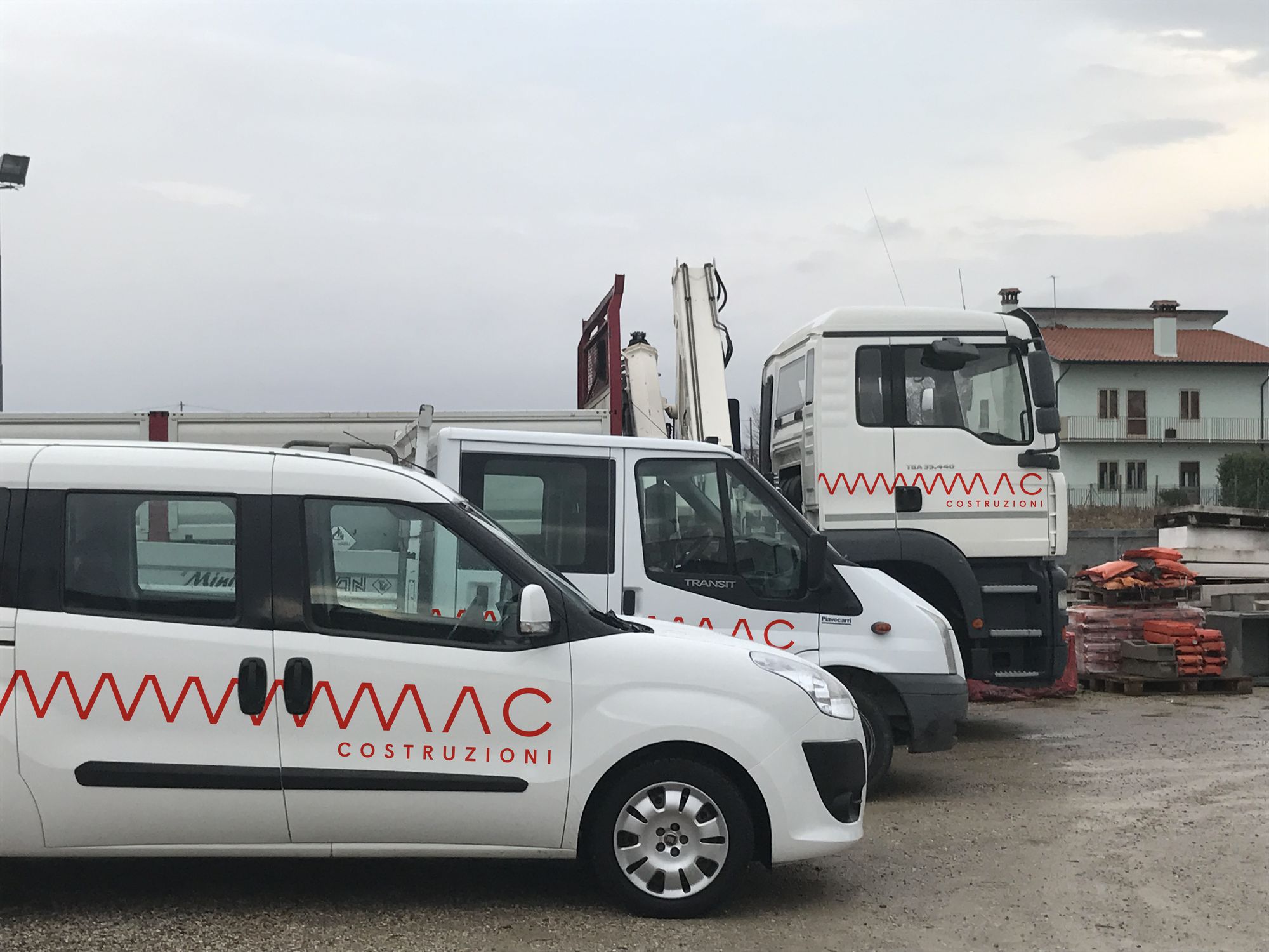 Furgoni e camion di MAC Costruzioni con la livrea rossa e il pattern a zig-zag sulle fiancate