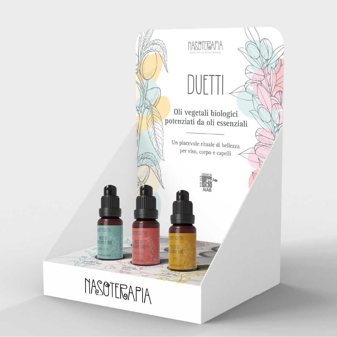 Dettaglio del flacone di olio di mandorla bio e legno di Ho con una mandorla sul piatto