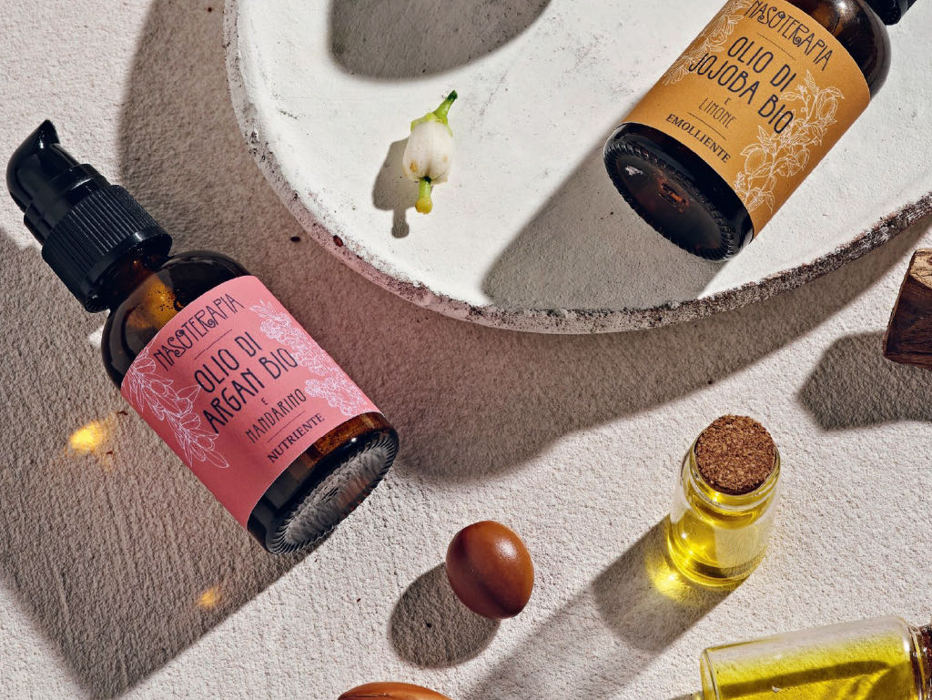 I flaconi di argan e jojoba con i semi di argan e le fiale d’olio