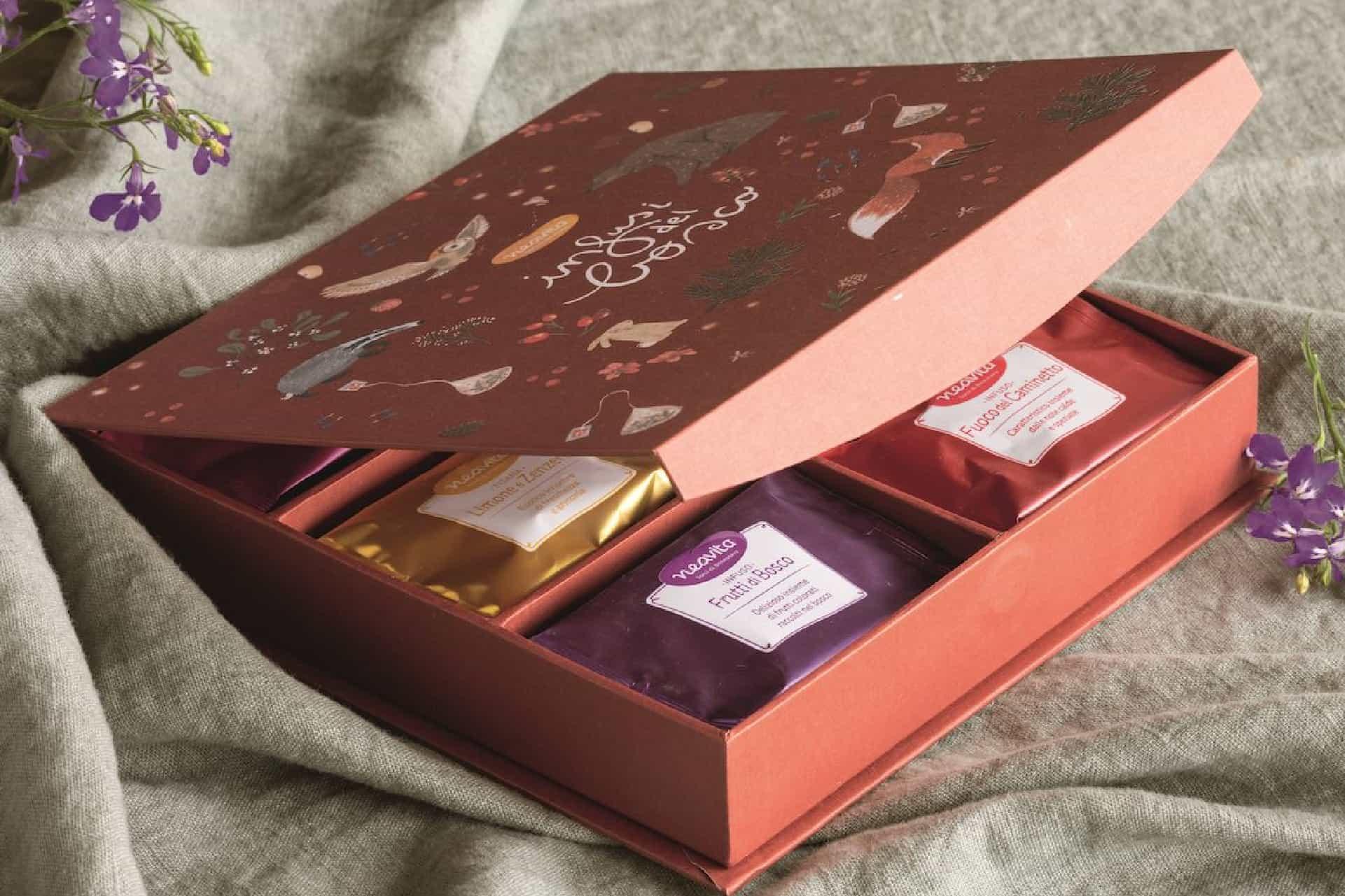 The Infusi del bosco gift box open, with the illustrated lid and the infusion sachets in their compartments