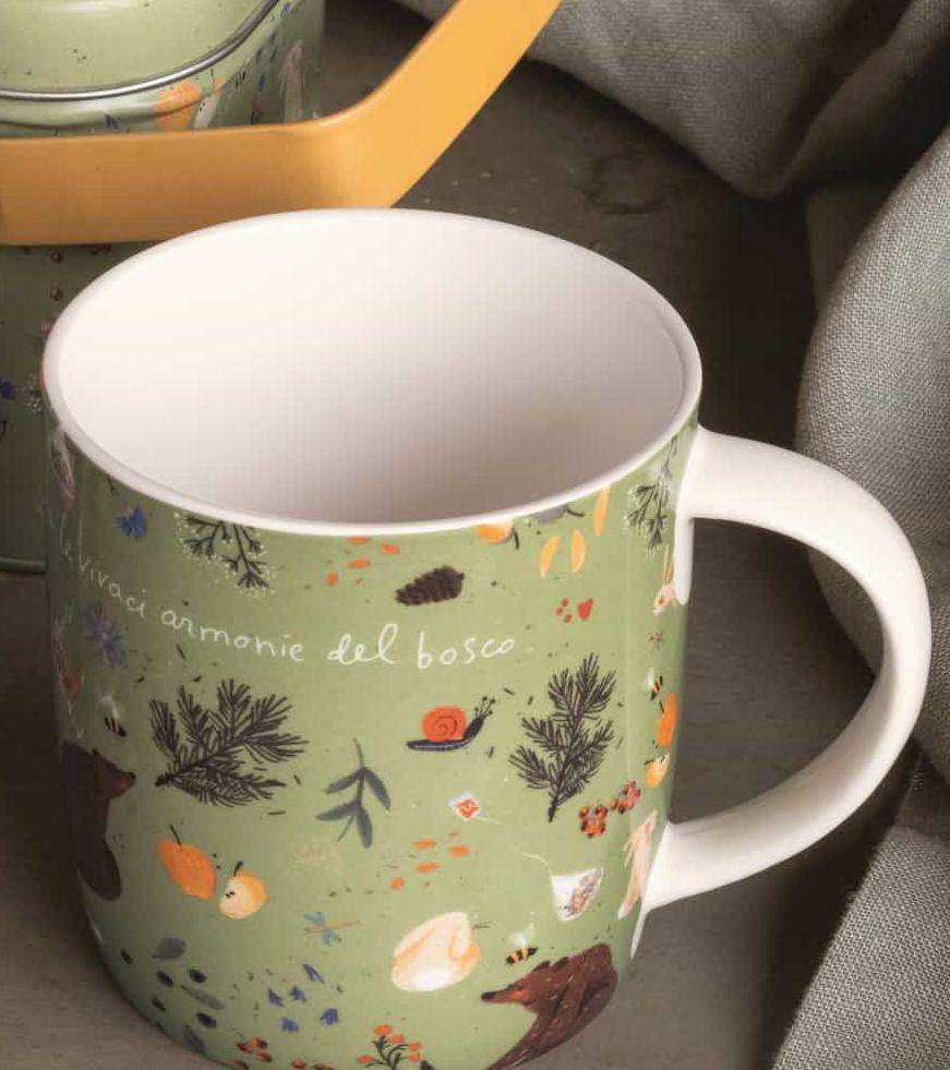 Detail of the green Infusi del bosco mug, with the phrase vivaci armonie del bosco and illustrated animals