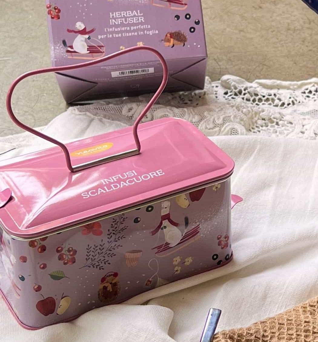 Detail of the pink Infusi scaldacuore tin, with the heart-shaped handle and winter illustrations