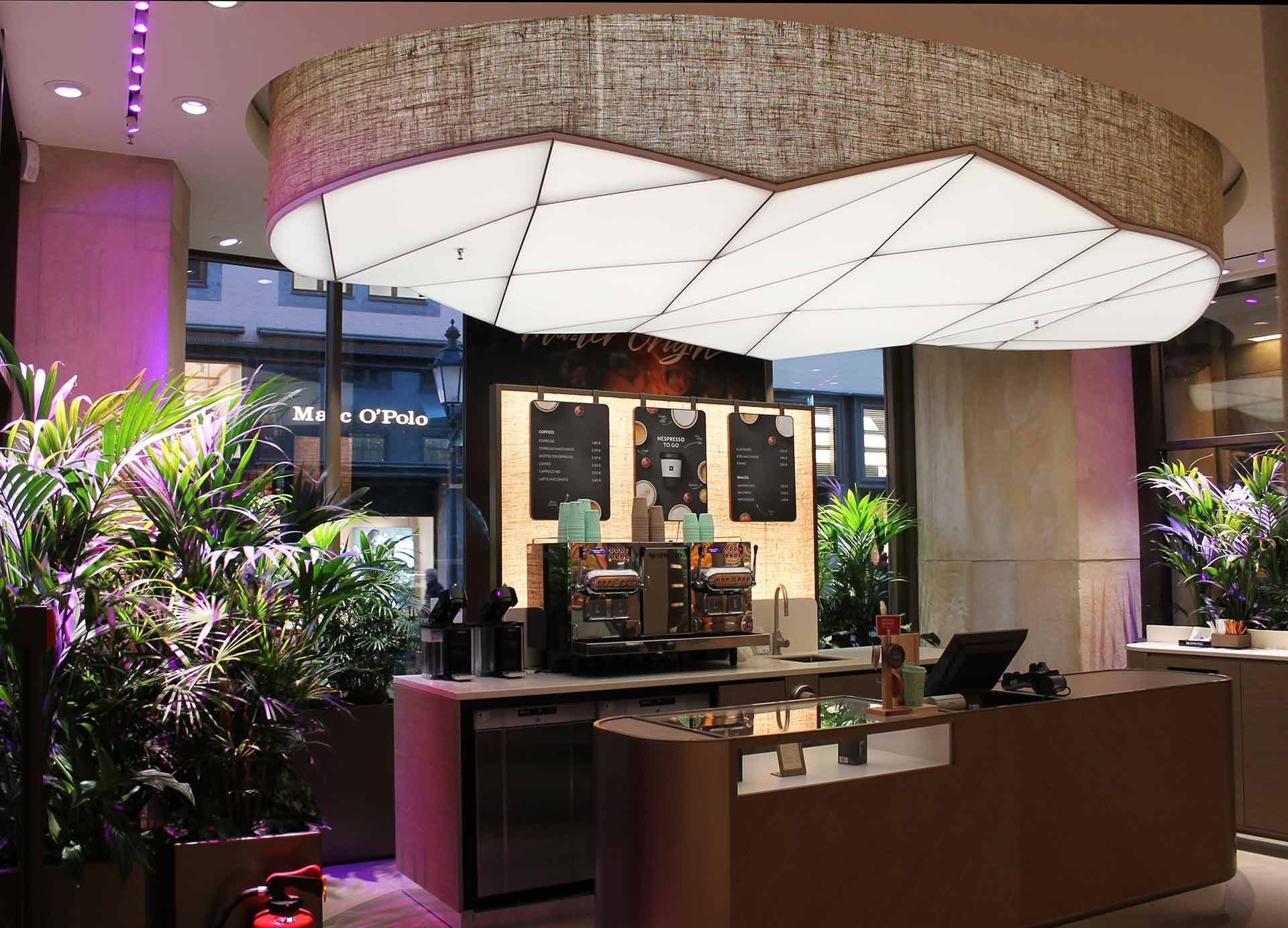 A backlit Savi stretch ceiling, shaped like a cloud above a bar counter