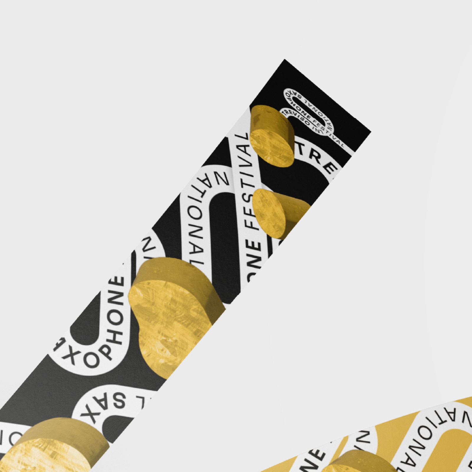 Braccialetto nero con il nome del festival in bianco e le forme d’oro